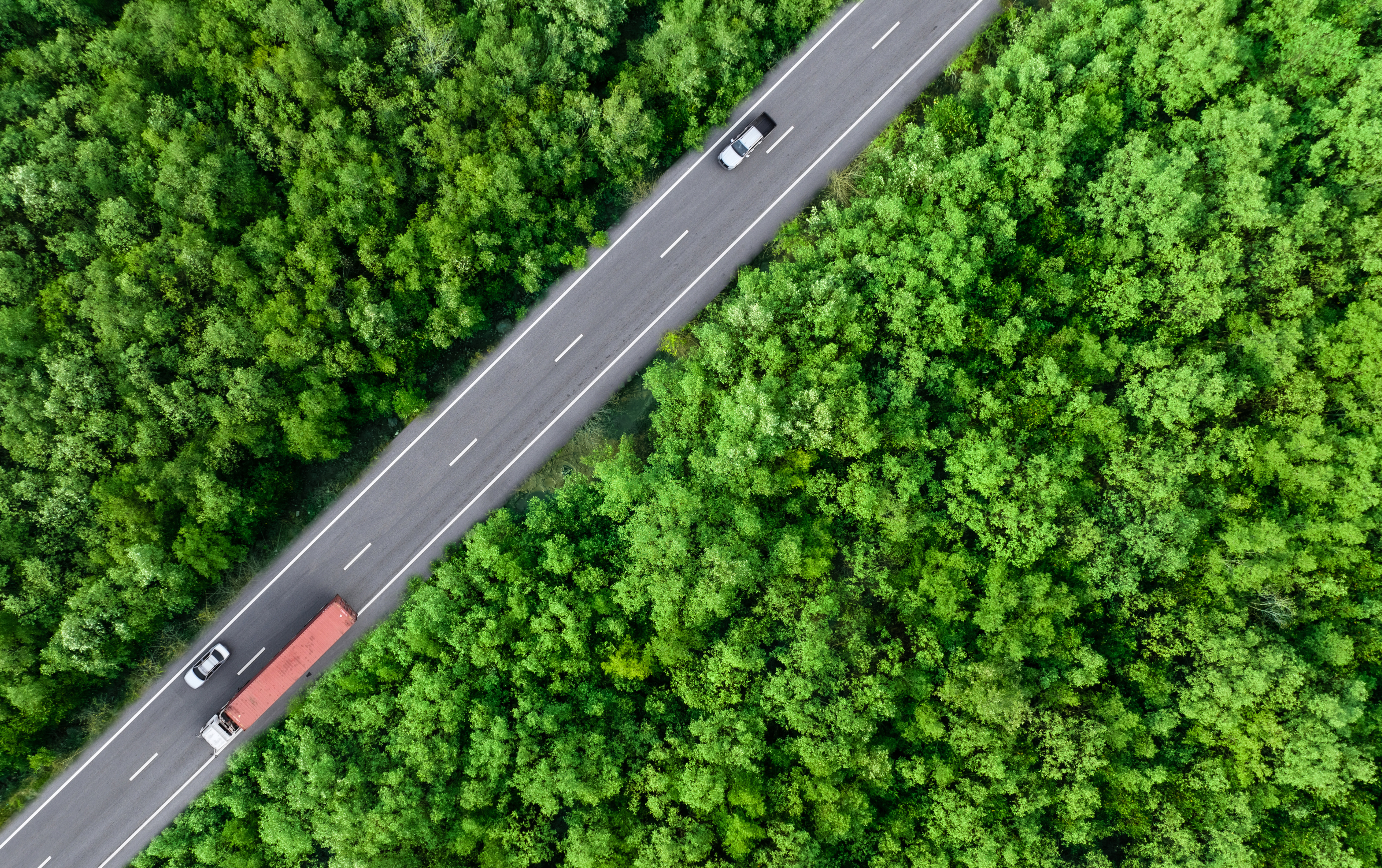 En vej der skærer sig gennem landskabet med biler og lastbilere kørende på den.