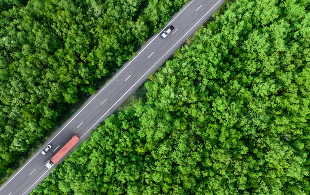 En vej der skærer sig gennem landskabet med biler og lastbilere kørende på den.