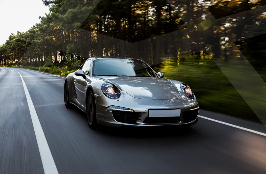 En leaset grå luksusbil der kører igennem landskabet med Krone Kapital logo.