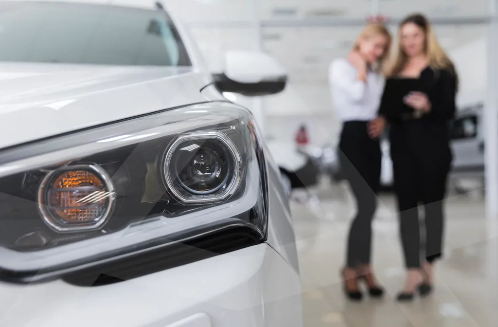 To kvinder der står og kigger på deres nye mulige leasingbil.