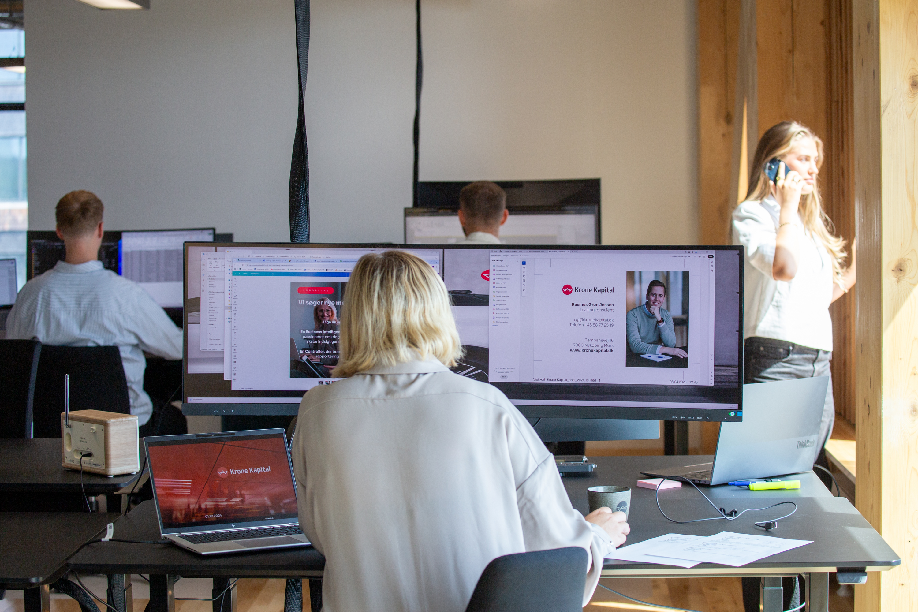 En almindelig dag på kontoret i Aarhus, hvor nogle er på computeren og andre taler i telefon.