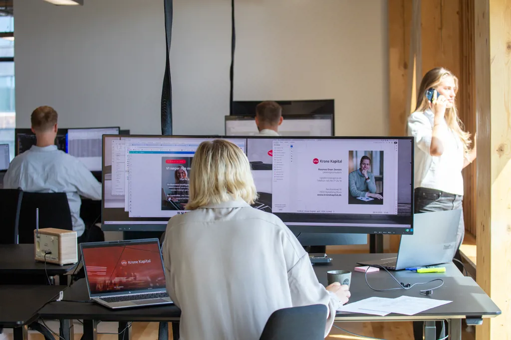 En almindelig dag på kontoret i Aarhus, hvor nogle er på computeren og andre taler i telefon.