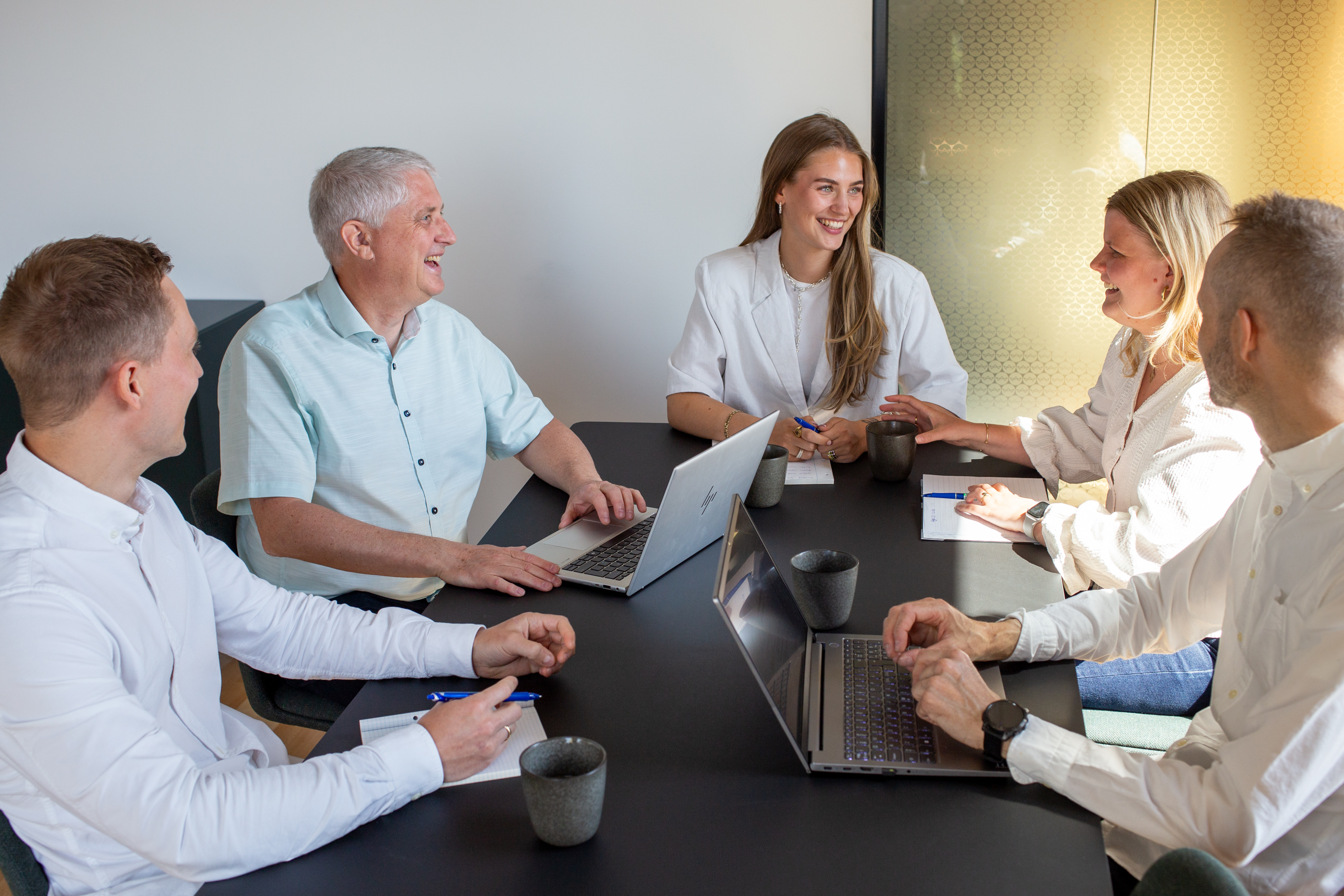 Glade kollegaer holder møde og drøfter leasing.