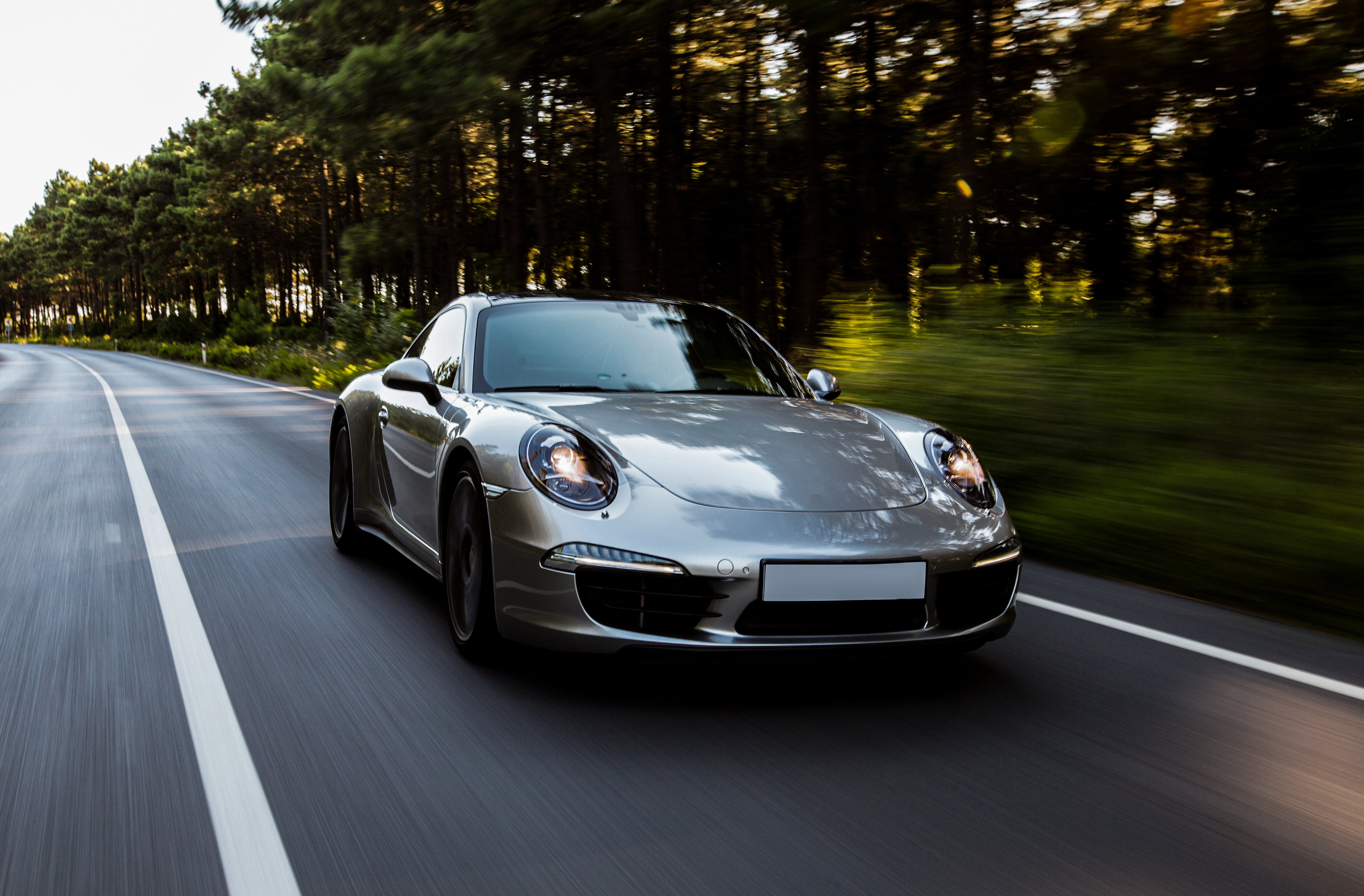 En leaset grå luksusbil der kører igennem landskabet.