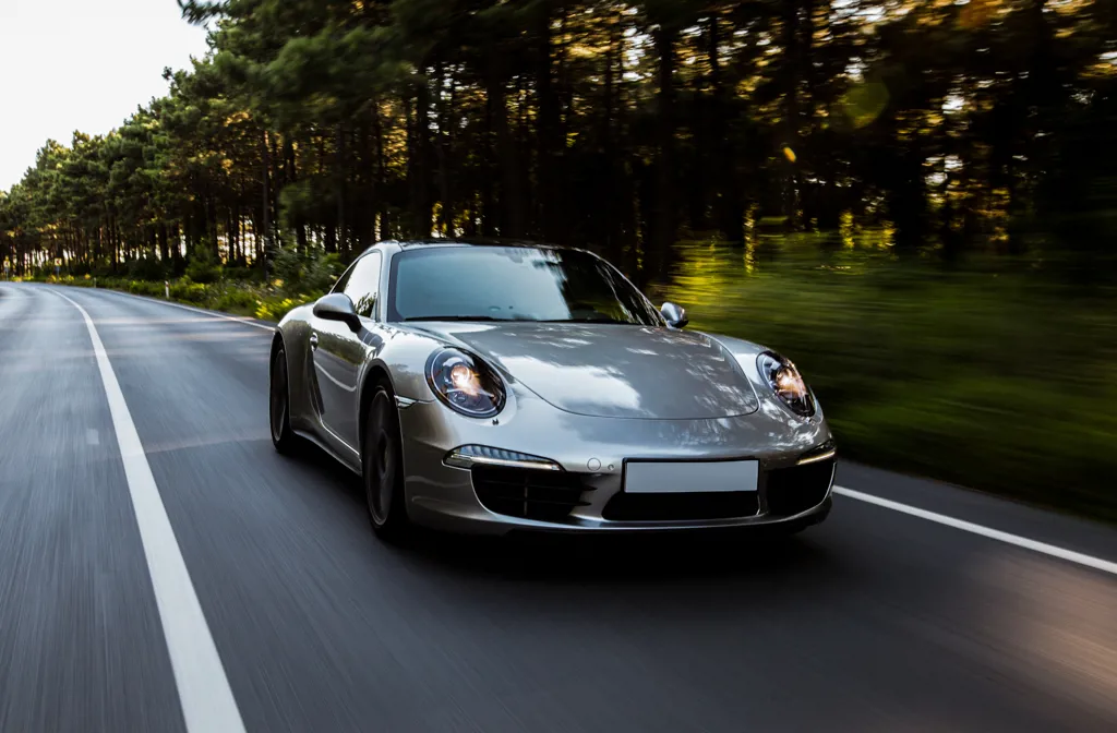 En leaset grå luksusbil der kører igennem landskabet.