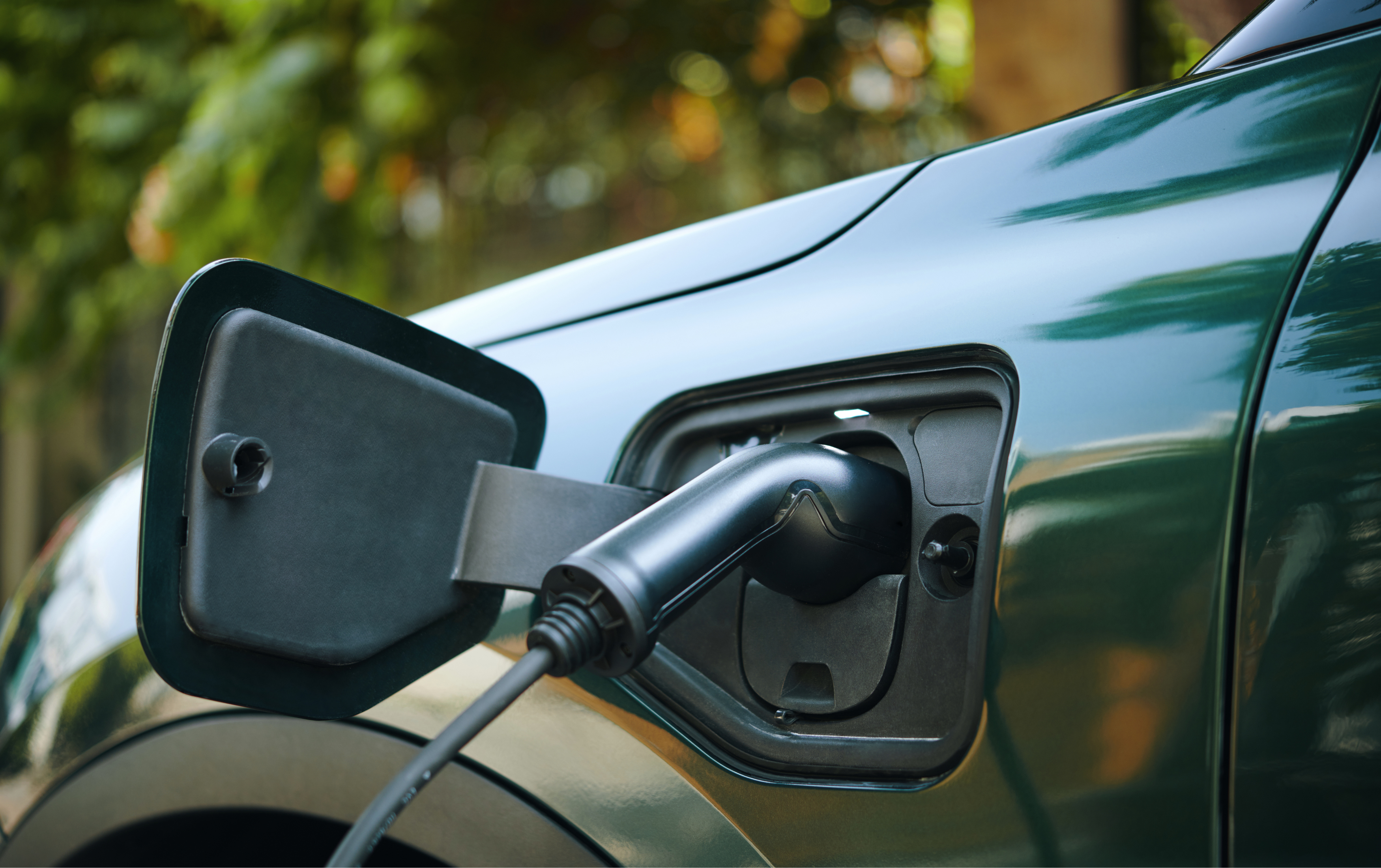 En grøn elbil der holder og lader.